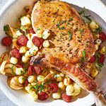 Chuleta de puerco sobre esquites